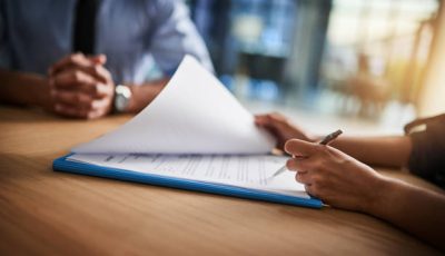 Cropped shot of a man and woman completing paperwork together at a desk
